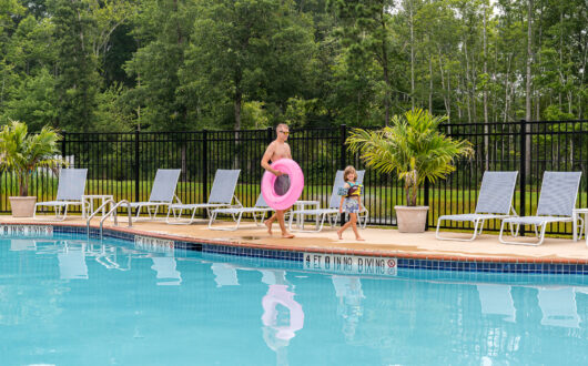 Dad and child walking on pool deck