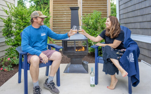 Couple enjoying fire pit while sipping wine on their private patio