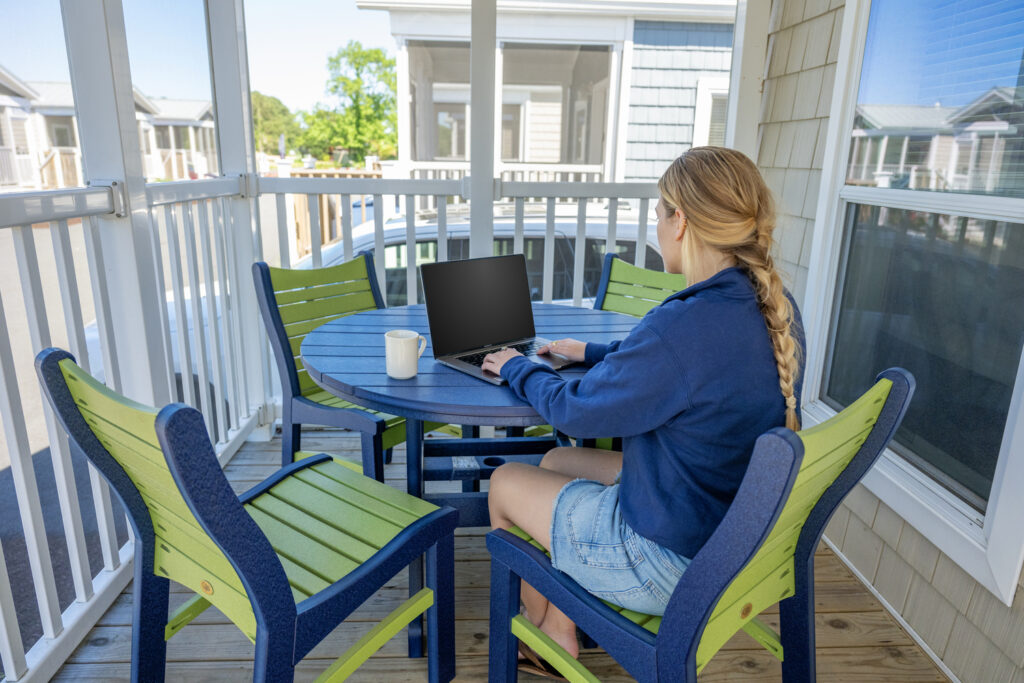 Someone on their computer on the screened in front porch